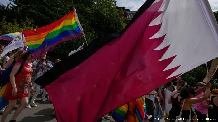 Foto de personas que portan banderas LGBTI y de Qatar en una imagen de archivo