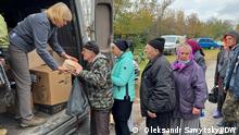 Una mujer entrega ayuda a vecinos de una localidad ucraniana.