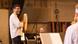 Keyvan Chemirani holds a percussion instrument during rehearsal, while musicians smile in the background.