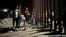 21.06.2022
epa10026773 Migrants walk behind the wall after crossing the Colorado River as hundreds cross the border between Mexico and the US in Yuma, Arizona, USA, 21 June 2022. Coming from all over the world, most of the migrants who cross the border where the wall ends at the limit of the Cocopah Indian Reservation, willingly turn themselves to US Border Patrol officers who will process them as they ask for asylum. EPA-EFE/ETIENNE LAURENT ATTENTION: This Image is part of a PHOTO SET