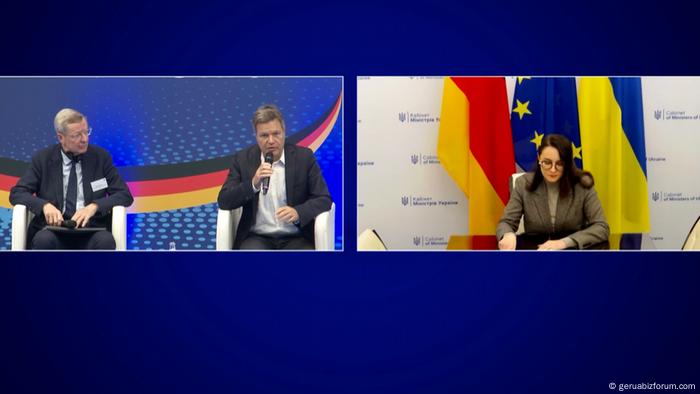 Screenshot vom deutsch-ukrainischen Wirtschaftsforum. Bundeswirtschaftsminister Robert Habeck und die ukrainische Wirtschaftsministerin Julia Sviridenko diskutieren miteinander. Sviridenko sitzt in Kiew und ist zugeschaltet, im Hintergrund sind die deutsche, die ukrainische und die EU-Flagge zu sehen. Habeck sitzt in Berlin neben dem Moderator und hat ein Mikrofon in der Hand. Screenshot vom deutsch-ukrainischen Wirtschaftsforum. Bundeswirtschaftsminister Robert Habeck und die ukrainische Wirtschaftsministerin Julia Sviridenko diskutieren miteinander. Sviridenko sitzt in Kiew und ist zugeschaltet, im Hintergrund sind die deutsche, die ukrainische und die EU-Flagge zu sehen. Habeck sitzt in Berlin neben dem Moderator und hat ein Mikrofon in der Hand.