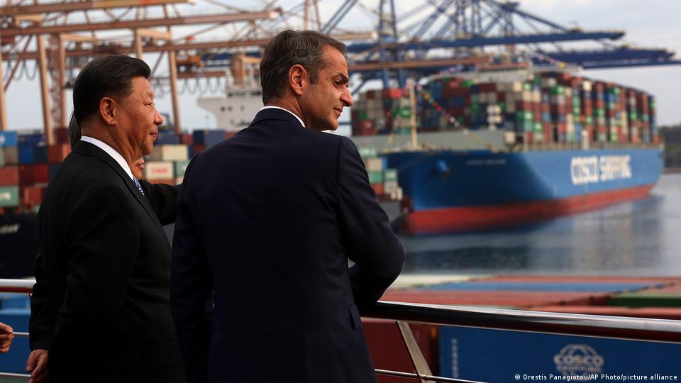 Presidente chinês, Xi Jinping, e premiê grego, Kyriakos Mitsotakis com navio cargueiro ao fundo