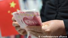 FUYANG, CHINA - APRIL 15, 2022 - A woman makes money in Fuyang City, Anhui Province, China, April 15, 2022. On the afternoon of April 15, 2022, the People's Bank of China (PBOC) decided to lower the reserve requirement ratio (RRR) for financial institutions by 0.25 percentage points on April 25, 2022 (excluding financial institutions that have implemented the 5% RRR), releasing a total of about 530 billion yuan of long-term funds.