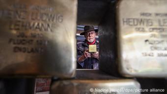 Gunter Demnig hinter aufgestapelten Stolpersteinen Gunter Demnig hinter aufgestapelten Stolpersteinen