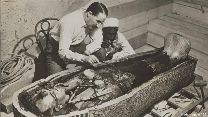 El egiptólogo Howard Carter elimina restos de aceite de una momia en la cámara funeraria de Tutankamón.