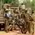 Burkinabe soldiers standing next to a military vehicle