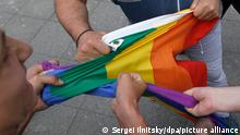 30.05.2015 epa04775298 Russian men hold a rainbow's flag during a rally of activists of the LGBT (lesbian, gay, bisexual, and transgender) community in front of the Moscow's mayor office building in Moscow, Russia, 30 May 2015. Homosexuals gathered to demand respect for people with different sexual preferences. Moscow city authorities turned down demands for a gay rights rally. EPA/SERGEI ILNITSKY ++