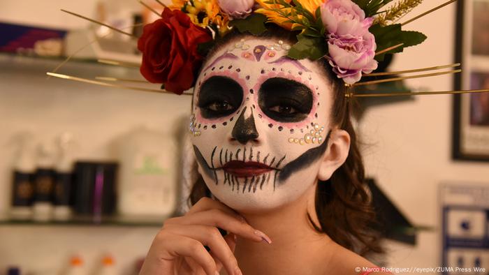 Mujer maquillada y con flores en la cabeza.