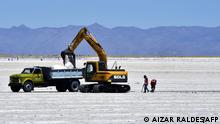 Employees work at the Salinas Grandes salt flat near the Kolla indigenous community of Santuario de Tres Pozos, which in 2019 expelled two mining companies from the salt flat, in the northern province of Jujuy, Argentina, on October 18, 2022. - The turquoise glimmer of open-air pools meets the dazzling white of a seemingly endless salt desert where hope and disillusionment collide in Latin America's lithium triangle. A key component of batteries used in electric cars, demand has exploded for the white gold found in Argentina, Bolivia and Chile in quantities larger than anywhere else in the world. (Photo by Aizar RALDES / AFP)
