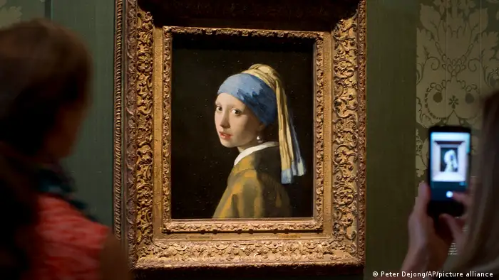 Das Gemälde Das Mädchen mit dem Perlenohrring: eine Frau mit blau-gelbem Kopftuch.