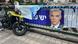 A motorbike alongside a bridge railing with a banner of a politician