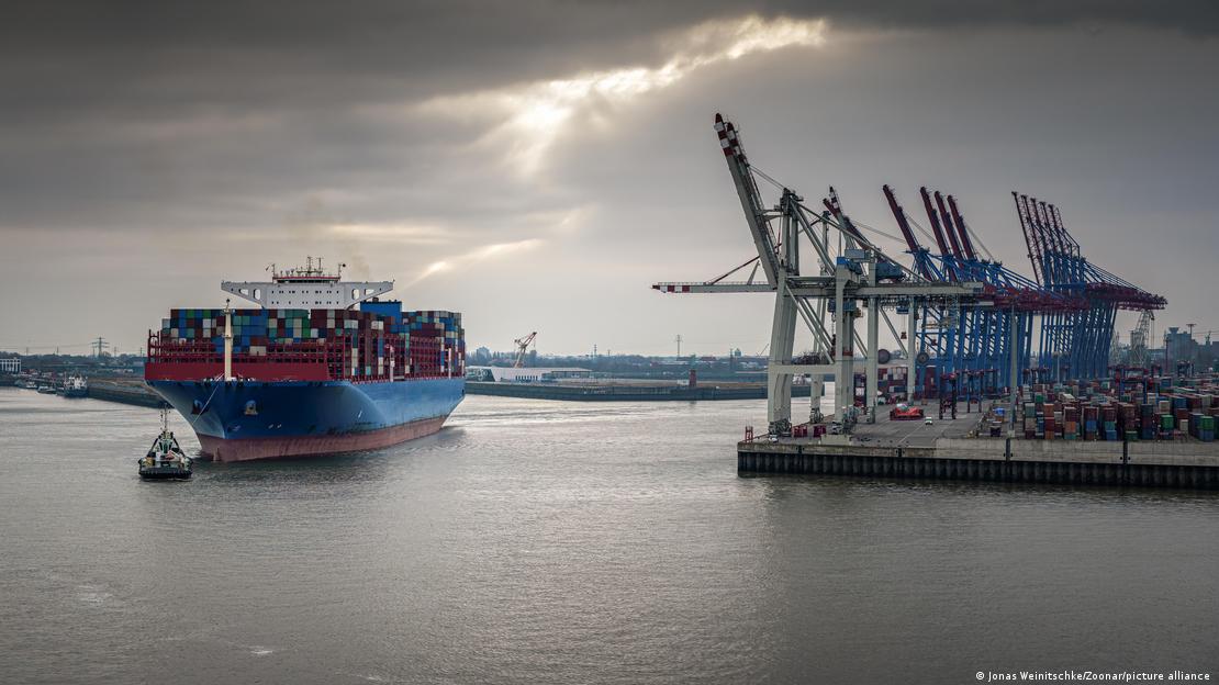 Vista do porto de Hamburgo com barco e guindastes