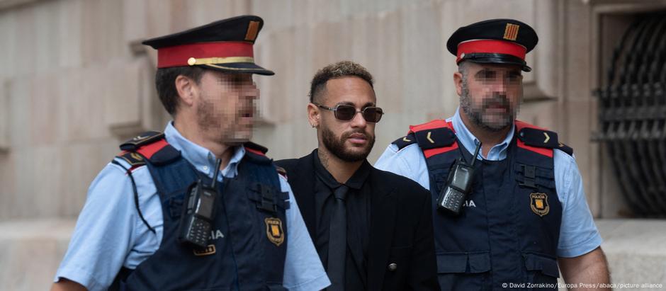 Escoltado por dois policias, Neymar chega para a primeira sessão do julgamento, no dia 17 de outubro