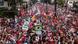 Lula atop a car at a campaign rally, surrounded by thousands of supporters wearing red