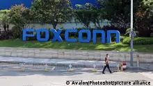 A man passes by a compound of the electronics manufacturer Foxconn, which is under strict access control to prevent Covid-19, in Shenzhen in south China's Guangdong province Saturday, Sept. 03, 2022., Credit:AH CHI / Avalon