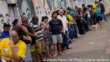 Brazilians line up outside a polling station for their turn to vote during a second round presidential election in Brasilia, Brazil, Sunday, Oct. 30, 2022. (AP Photo/Eraldo Peres)