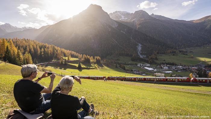 Ein Paar beobachtet wie sich der Schweizer Rekordzug durch die Alpen schlängelt.