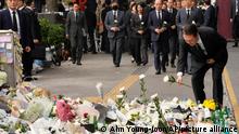 South Korean President Yoon Suk Yeol places a flower to pay tribute to victims of a deadly accident following Saturday night's Halloween festivities on a street near the scene in Seoul, South Korea, Tuesday, Nov. 1, 2022. (AP Photo/Ahn Young-joon)