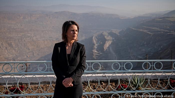 Die deutsche Außenministerin Annalena Baerbock steht vor einem mit Kreisen und Kreuzen verzierten Gitter in einer Bergbau-Anlage in Usbekistan