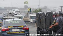 01.11.2022, Brasilien, Embu Das Artes: Lastwagenfahrer blockieren die Autobahn, um gegen die Niederlage des ehemaligen brasilianischen Präsidenten Bolsonaro bei der Präsidentschaftswahl zu protestieren, während Bereitschaftspolizisten eine Blockade vor den Demonstranten bilden. Foto: Andre Penner/AP/dpa +++ dpa-Bildfunk +++