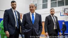 Likud party leader and former Israeli Prime Minister Benjamin Netanyahu (C) leaves a polling station after casting his ballot during the 2022 Israeli general election.