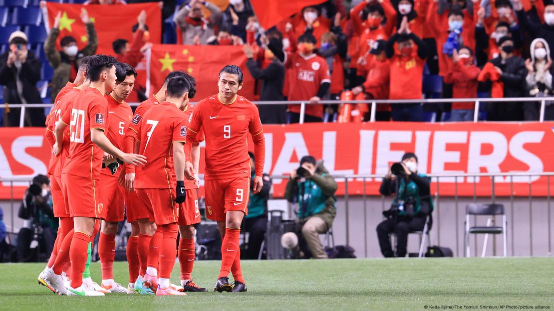 Jogadores da seleção chinesa em campo, com uniformes vermelhos