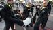 Police removing climate activists from a street in Berlin, with three officers in the foreground carrying one person who is not resisting but not cooperating. October 13, 2022. Police removing climate activists from a street in Berlin, with three officers in the foreground carrying one person who is not resisting but not cooperating. October 13, 2022.