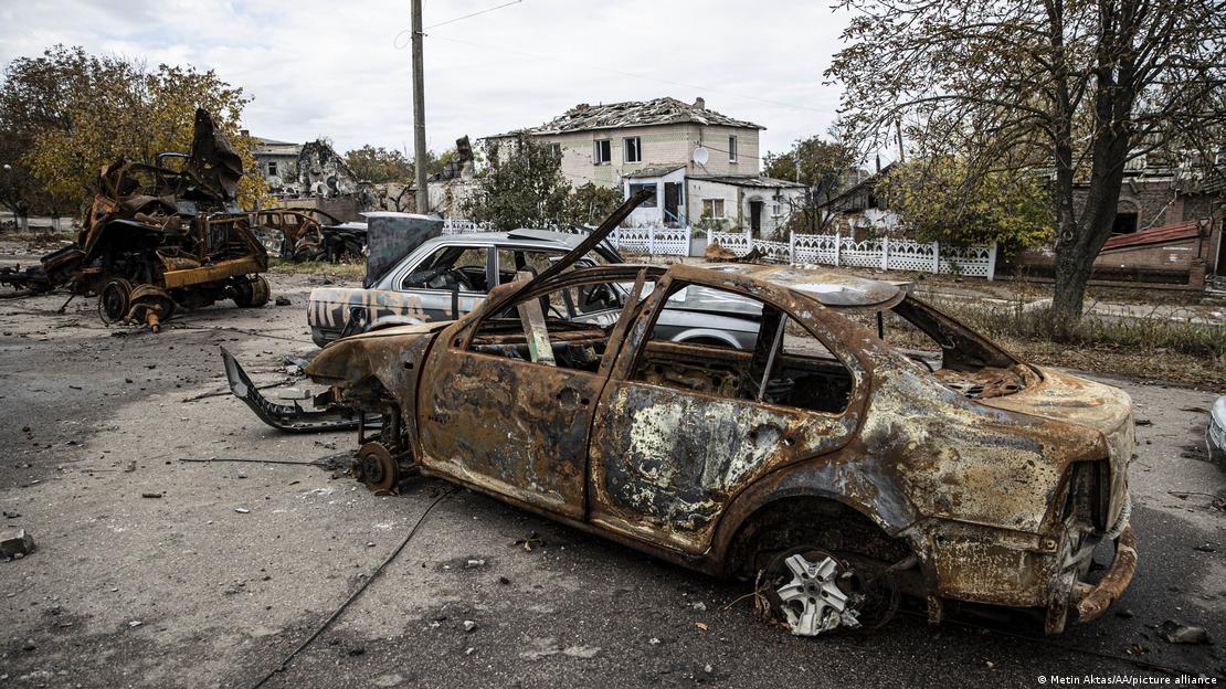 A imagem mostra veículos completamente destruídos e também o telhado de uma casa, ao fundo, que foram atingidos por bombardeios na região de Kherson, no sul da Ucrânia, em meio à invasão russa.