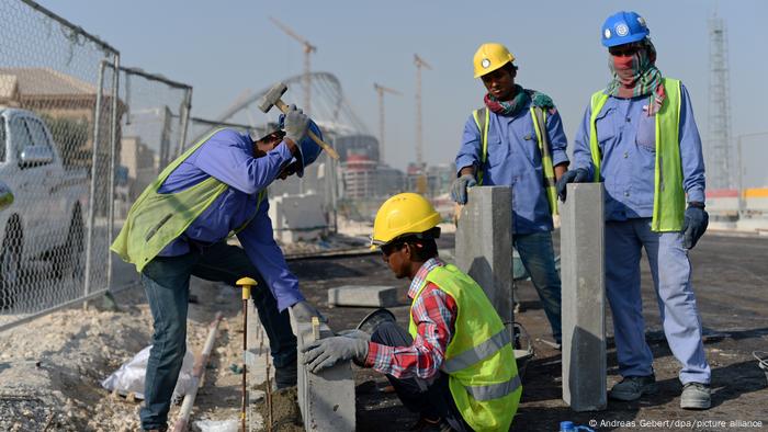 Trabajadores migrantes de India y Bangladesh instalan un bordillo en una carretera frente al estadio Khalifa en Doha, Qatar, en enero de 2017.
