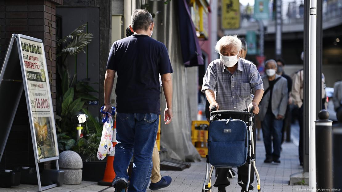 Idoso japonês andando numa rua de Tóquio