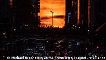 Der Sonnenuntergang von der East 42nd Street aus gesehen. Als «Manhattanhenge» wird dieses Phänomen bezeichnet, wenn das Licht der aufgehenden oder untergehenden Sonne in gerade Linie durch die Schluchten der Ost-West-Straßen von Manhattan scheint. +++ dpa-Bildfunk +++