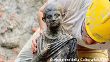 A worker holds a 2,300-year-old bronze statue which has been discovered in San Casciano dei Bagni, Italy, in this handout photo obtained by Reuters on November 8, 2022. Ministero della Cultura/Handout via REUTERS ATTENTION EDITORS THIS IMAGE HAS BEEN SUPPLIED BY A THIRD PARTY. NO ARCHIVES. NO RESALES
