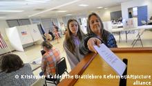 Lara Sisko drops her ballot into the box at a polling location in Hinsdale, N.H., as her granddaughter, Ki'ara, 14, watches during the midterm elections on Tuesday, Nov. 8, 2022. (Kristopher Radder/The Brattleboro Reformer via AP)