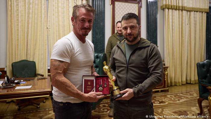 El actor Sean Penn entregándole una estatuilla de los Oscar al presidente de Ucrania, Volodimir Zelenski.