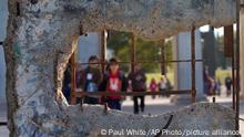 In this picture taken Thursday, Nov. 6, 2014, children visit a park where an original section of the Berlin wall is displayed in Torrejon de Ardoz near Madrid. The wall that once separated East from West Berlin has largely disappeared from the city. The few sections that remain stand as potent monuments to the ideological divisions of the Cold War. But 25 years after the Berlin Wall fell, some 120 parts of it can now be found in more than 40 countries, from Britain to South Africa and the United States. (AP Photo/Paul White)