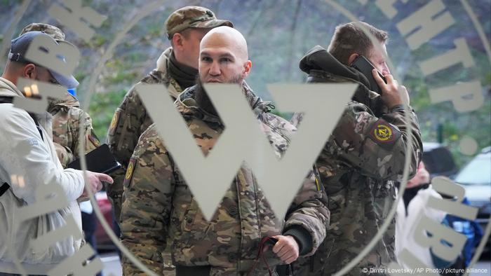 Hombres esperando frente al centro de operaciones de Wagner en San Petersburgo.