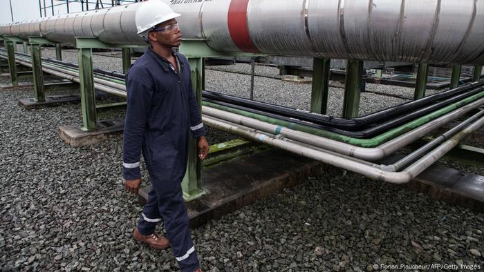 Mann vor Gaspipeline in Nigeria
