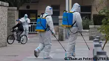 Pandemic prevention workers in protective suits spray disinfectant in a residential compound that was placed under lockdown as outbreaks of coronavirus disease (COVID-19) continue in Beijing, China November 9, 2022. REUTERS/Thomas Peter