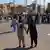 Dos hombres iraníes tomados de la mano hacen el signo de la victoria durante una manifestación en la ciudad iraní de Zahedan, el 11.11.2022. Las protestas por la muerte de la joven Mahsa Amin,i el 16 de septiembre pasado, van a cumplir dos meses.