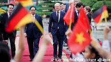 13.11.2022, Vietnam, Hanoi: Bundeskanzler Olaf Scholz (SPD) wird von Pham Minh Chinh (l), Premierminister der Sozialistischen Republik Vietnam, mit militärischen Ehren empfangen. Vietnam ist der erste Stop des Bundeskanzlers auf dem Weg zum G20-Gipfel. Foto: Kay Nietfeld/dpa +++ dpa-Bildfunk +++