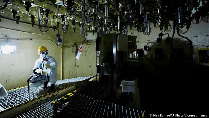 Un trabajador con traje de protección en una sala de una planta de energía atómica.