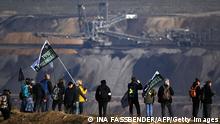 Protesters stand in front of a brown coal excavator during a demonstration at the Garzweiler lignite open cast mine near Luetzerath, western Germany, on November 12, 2022. - German energy provider RWE is planning to entirely demolish houses in the village of Luetzerath for coal mining. The country's economy has restarted part of its mothballed inventory of coal power plants to relieve the pressure on gas-powered facilities, following a cut to supplies from Russia in the wake of the invasion of Ukraine. Several thousand protesters are expected to descend on Luetzerath, now a symbol of the resistance to fossil fuels, to urge more action from participants in the COP27 conference in Egypt. (Photo by INA FASSBENDER / AFP) (Photo by INA FASSBENDER/AFP via Getty Images)