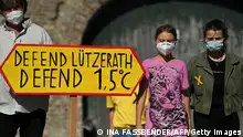 Swedish climate activist Greta Thunberg (C) and German climate activist Luisa Neubauer (R) together with other activists arrive to give a press statement in Luetzerath, western Germany, on September 25, 2021, one day ahead of the German federal election. - Luetzerath is one of several villages threatened by the expansion of a mine which is allowed to produce after the recent government's legislation setting a 2038 coal phase-out deadline. (Photo by Ina Fassbender / AFP) (Photo by INA FASSBENDER/AFP via Getty Images)