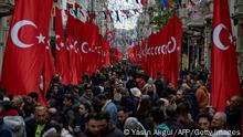 TOPSHOT - Pedestrians walk through Istiklal street in Istanbul, adorned all along with Turkish national flags on November 14, 2022 one day after a bomb killed six people in the busy central shopping street of the Turkish capital. - Turkey's interior minister accused the outlawed Kurdistan Workers' Party (PKK) on November 14, of responsibility for a bombing in a busy Istanbul street that killed six people and wounded scores, saying more than 20 people have been arrested. (Photo by Yasin AKGUL / AFP) (Photo by YASIN AKGUL/AFP via Getty Images)