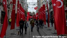 Pedestrians walk through Istiklal street in Istanbul, adorned all along with Turkish national flags on November 14, 2022 one day after a bomb killed six people in the busy central shopping street of the Turkish capital. - Turkey's interior minister accused the outlawed Kurdistan Workers' Party (PKK) on November 14, 2022 of responsibility for a bombing in a busy Istanbul street that killed six people and wounded scores, saying more than 20 people have been arrested. (Photo by Yasin AKGUL / AFP) (Photo by YASIN AKGUL/AFP via Getty Images)