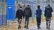 Four youths in front of a fence and accomodation facility for refugees Four youths in front of a fence and accomodation facility for refugees