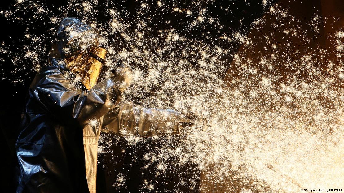 Trabalhador de siderúrgica em meio a faíscas de ferro bruto saindo de um forno em uma fábrica de aço da ThyssenKrupp em Duisburg, oeste da Alemanha, em 14 de novembro de 2022.