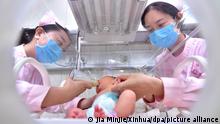 Die Krankenschwestern Mo Fei (l) und An Keran geben in einem Krankenhaus in Xinle einem Neugeborenen ein Fläschchen. Die Zahl der Menschen auf der Welt übersteigt nach UN-Berechnungen in etwa am 15.11.2022 die Schwelle von acht Milliarden. (zu dpa UN: Menschheit überschreitet Acht-Milliarden-Schwelle - Wiederholung vom 07.11.2022) +++ dpa-Bildfunk +++