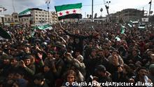 Thousands of anti-Syrian government protesters shout slogans and wave revolutionary flags, to mark 10 years since the start of a popular uprising against President Bashar Assad's rule, that later turned into an insurgency and civil war, In Idlib, the last major opposition-held area of the country, in northwest Syria, Monday, March 15, 2021. (AP Photo/Ghaith Alsayed)
