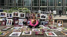 Wafa Mustafa, in April 2021 outside a courtroom in Koblenz, where two former Syrian military intelligence officers were on trial. She sat alone among 121 photos of missing persons in the regime's prisons, including her father, who has been arrested since the start of the Syrian uprising. Photo: Wafa Mustafa.